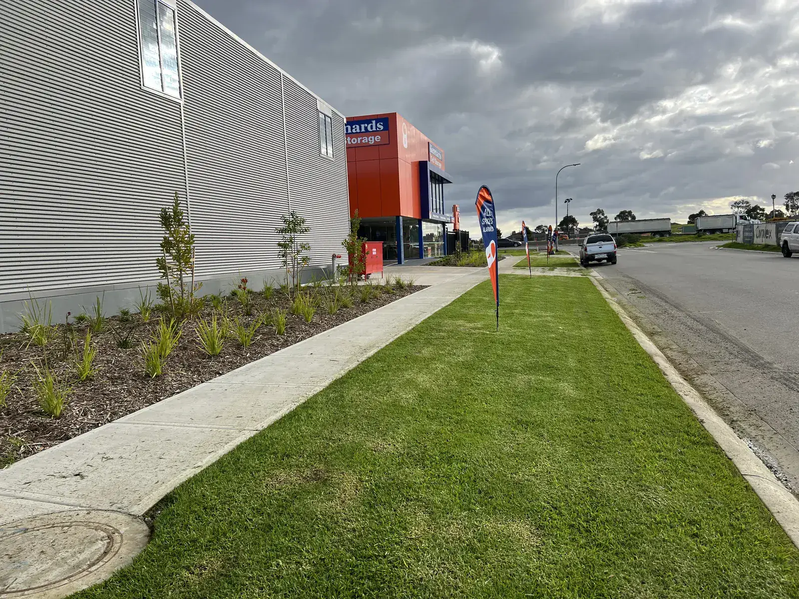 A new industrial frontage on Peet Street, Pakenham, with young plantings and a freshly mown nature strip