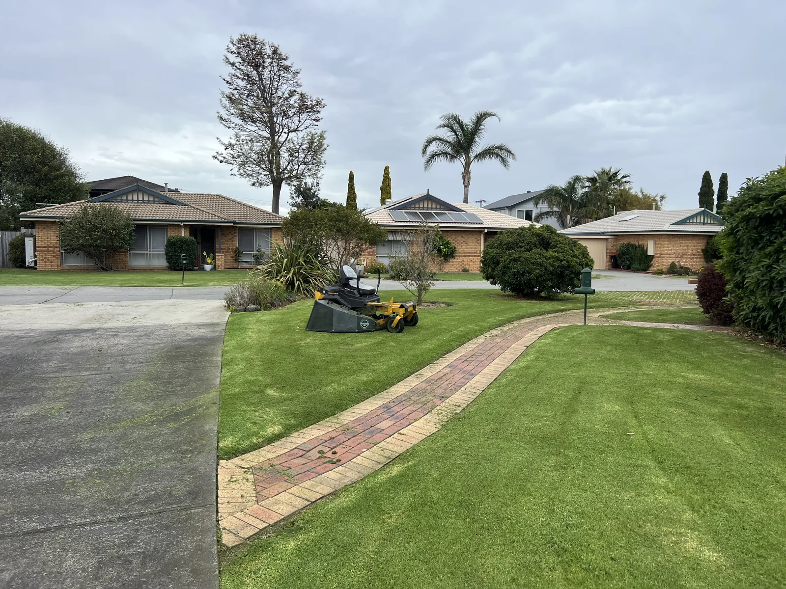 Ride-on mower on freshly striped body corporate lawns in south east Melbourne